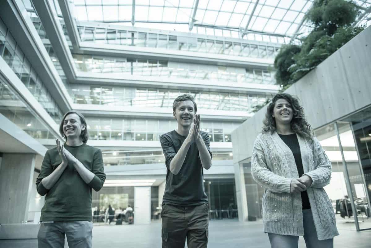 Een groep mensen staat in een atrium.